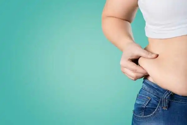 Image of woman pinching her love handles to show weight gain Tetbury